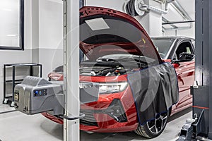 car repair shop worker checks and adjusts the headlights of a car\'s lighting