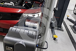 car repair shop worker checks and adjusts the headlights of a car\'s lighting