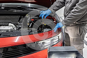 car repair shop worker checks and adjusts the headlights of a car's lighting