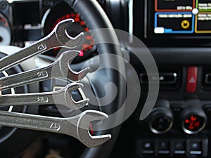 Car Repairing Concept. Wrenches In Front Of Steering Wheel And Central Panel In Car Interior