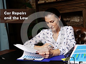 Car Repairs and the Law inscription. Female office workers with yellow shirt holding and writing documents on office desk