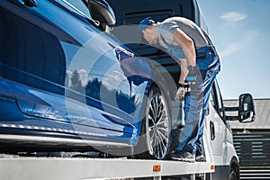 Car Repossession Worker Securing Vehicle on His Towing Truck