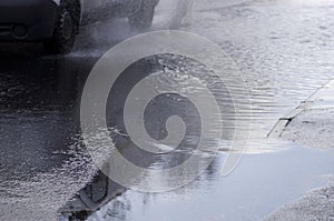 Car rides on big puddle. Water splash. Manchester England.