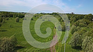 Car rides on country field road on sunny summer day. Clip. Car is moving along field road in green field in summer