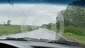 Car rides on road in the rain, windshield video