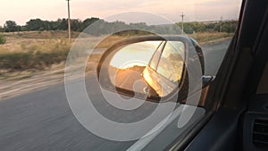 Car rides on the road, a view of the side rearview mirror, reflection in the mirror. View of the bay from the car. Close