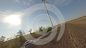 Car riding near field and windmill