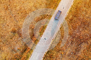 Car on the road through autumn countryside, aerial view