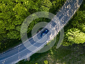 Car on road in the forest in summer time nature from air . View from a drone. Aerial view