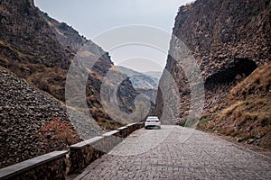 Car on a road way to an important natural attraction of Armenia - a Symphony of Stones or basalt Pillars