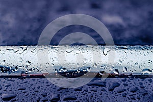 Car roof railing abstract closeup with rain drops