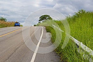 A car on rural road ahead to the mountain