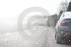 A car on a rural road in the first autumn snow. The first winter