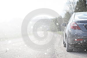 A car on a rural road in the first autumn snow. The first winter