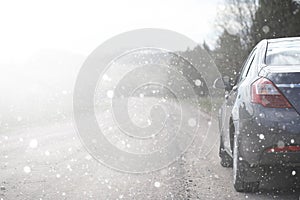 A car on a rural road in the first autumn snow. The first winter