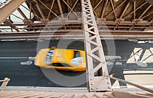 Car rushing over Brooklyn Bridge