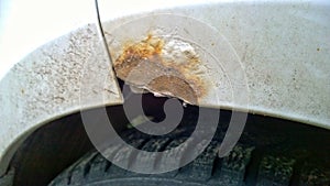 Car with rust, corrosion, defects and scratches, close up. How to remove rusty surface from a vehicle. Concept of providing qualit