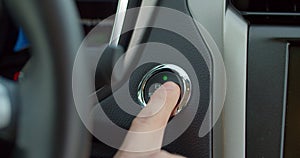 Car`s ignition button is getting pushed to start and stop the vehicle. pushing power ignition button to start keyless