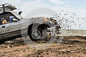 A car`s racing in mud during an off-road racing competition.