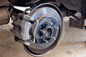 The car\'s wheels were removed, exposing the discs and disc brakes for tire changes and repairs
