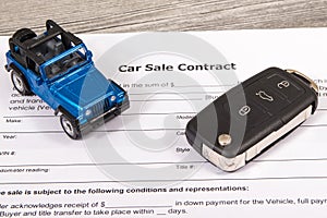 Car sale contract, blue toy car and black key. Sales, purchases of vehicle