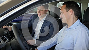 Car sale, Young man sitting in car, pro salesman Advises male client in motor show, Auto business, happy male buy car at