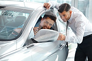 Car Sales Consultant Showing a New Car to a Potential Buyer in S photo