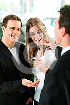 Car sales - key being given to couple