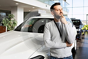 car sales manager at car dealership looking ahead thoughtfully