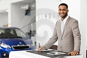 Car Sales Manager Standing In Luxury Dealership Office, Copy Space