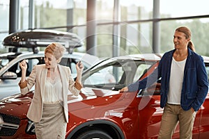 Car sales manager telling about the features of the car to the customers at the dealership