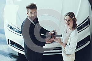 Car Salesman Giving Key of New Auto to Owner