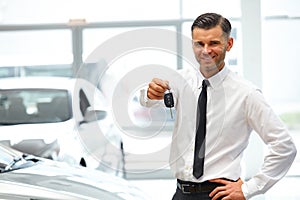 Car Salesman Giving Key of New Car at Showroom