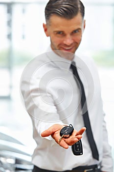 Car Salesman Giving Key of New Car at Showroom