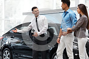 Car Salesman Invites Customers at Showroom.