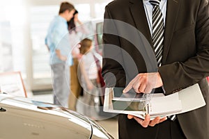 Car salesman's hands holding color swatches