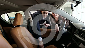 Car salesman working with customers in the showroom.