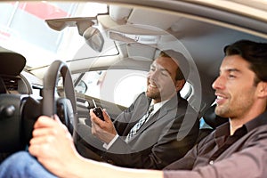 Car salesmen and customers talk about the technology of a car in