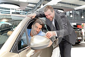 Car salesmen and customers talk about the technology of a car in