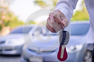 Car salesmen and keys presenting car trading