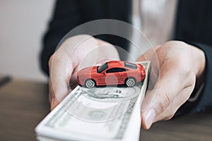 Car salespeople are submitting cash with model cars to customers with concept of buying a new car photo