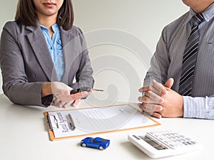 Car saleswoman giving the key to customer and signed a car rental service lease contract