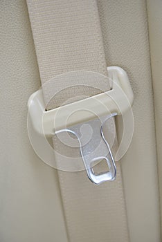 Car seatbelt on the beige leather
