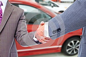 Car seller and client handshake.