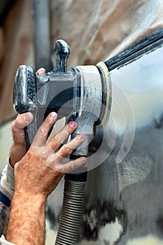 Car service, auto mechanic using a power buffer machine photo