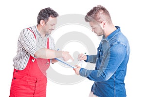 Car service client signing document on clipboard with mechanic