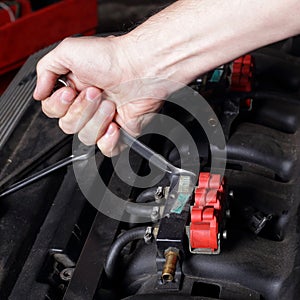 Car service - Engine repair mechanic hand with wrench