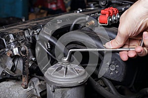 Car service - Engine repair mechanic hand with  wrench fuel filter