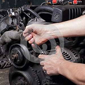 Car service - Engine repair mechanic hands with wrench generator nut