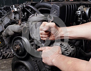 Car service - Engine repair mechanic hands with wrench generator  nut